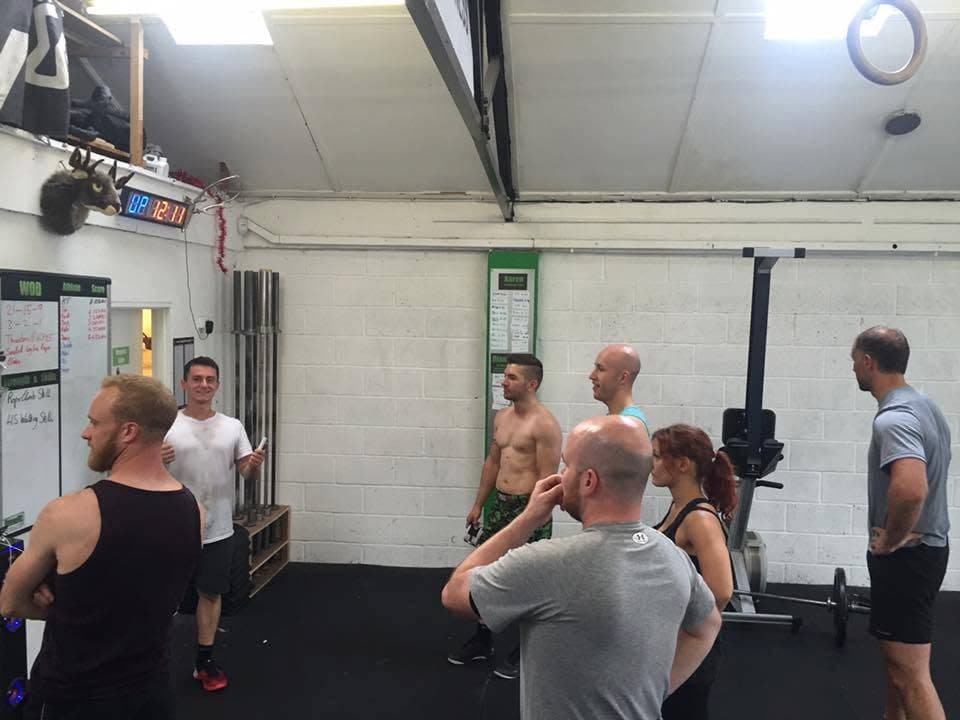 Nick coaching a class from the whiteboard at a CrossFit box